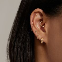 a close up of a woman's ear with three small gold stars on it