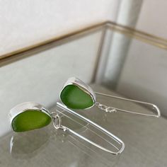 A delicate yet bold statement. Each pair of earrings is handmade so you'll appreciate every subtle intricacy. Can be worn while taking a casual stroll on the beach combing for sea glass. Or, paired with your favorite evening wear to complement those amazing shoes you just bought.For a made to order you would choose your sea glass or supply me with your own sea glass that will be made into a *similar* set of earrings. Please message me with any questions!They arrive in sage jewel box with ribbon. Sea Glass Silver Jewellery, Sea Glass Jewellery Ideas, Sea Glass Jewellery, Earrings Piece, Fish Jewelry Silver, Sea Glass Jewelry Earrings, October Jewelry, Seaglass Jewelry, Fish Jewelry