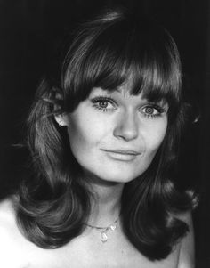 a black and white photo of a woman with long hair wearing a strapless dress