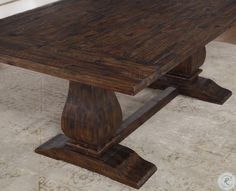 a large wooden table with two legs on the top and one leg extended to the side