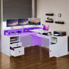 a computer desk with two monitors on it and purple lighting under the desk is an office chair