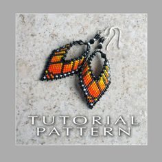 two orange and black beaded earrings sitting on top of a white surface with the words,