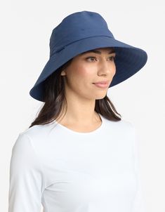 a woman wearing a white top and blue hat