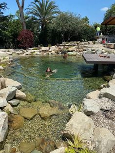 a man swimming in a pool surrounded by rocks