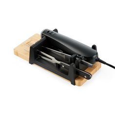 a knife sharpener sitting on top of a cutting board next to an electric cord