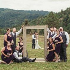 a group of people posing for a photo in front of a mirror on the grass