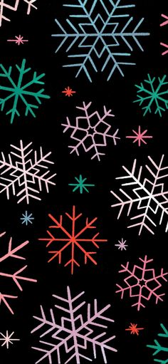 snowflakes on a black background are colored pink, blue, and green with red centers