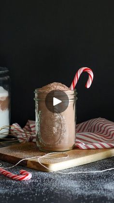 a jar filled with chocolate pudding next to two candy canes