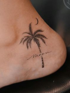 a woman's foot with a palm tree and the word moon tattooed on it