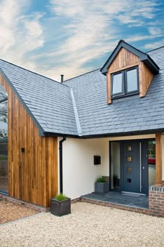 a house with a black front door and brown shingles on the roof is shown