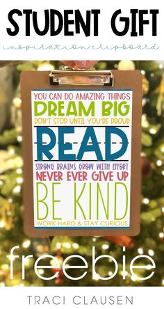 a clipboard with the words dream big read and be kind on it in front of a christmas tree