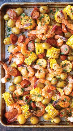 shrimp, corn and potatoes on a baking sheet