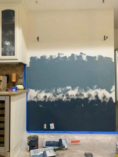 a kitchen with blue and white paint on the wall next to a stove top oven