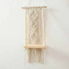 a macrame hanging on the wall with beads and wood bead work in it