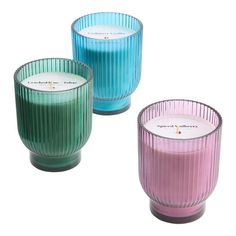 three different colored candles sitting next to each other