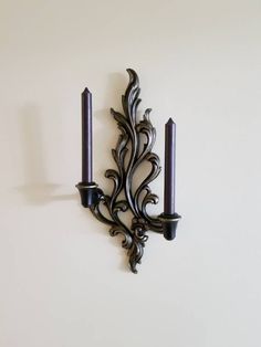 a wall mounted candle holder with two candles