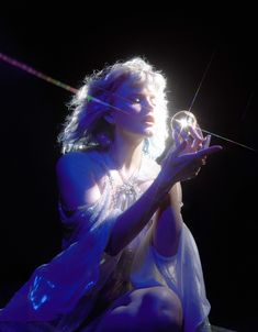 a woman sitting on the ground holding a microphone