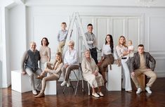 a group of people posing for a photo in front of a white wall and wooden floor