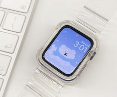 an apple watch sitting on top of a white table next to a keyboard and mouse