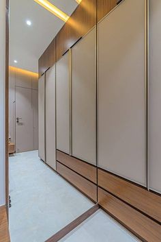 an empty walk - in closet with mirrored doors and wood trimming on the walls