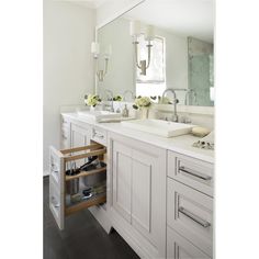 a white bathroom with two sinks and drawers