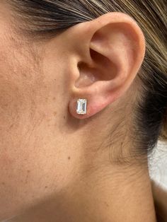 a close up of a person wearing an earring with a diamond in the middle