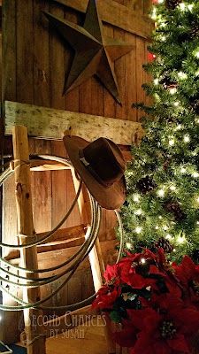 a christmas tree in a barn with a cowboy's hat and star on it