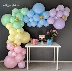 a table topped with balloons next to a wall