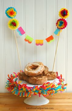 there are donuts on top of the cake and some streamers around it for decoration