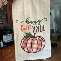 someone is holding up a towel that says happy fall y'all with a pumpkin on it