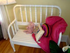 a pink teddy bear sitting on a white bench