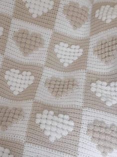 a crocheted blanket with hearts on it