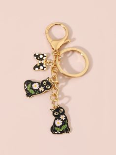 the keychain is decorated with black cats and daisies