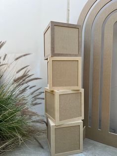 three cardboard boxes stacked on top of each other in front of a door and grass