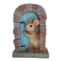 a figurine of a mouse peeking out from a brick wall with a blue door