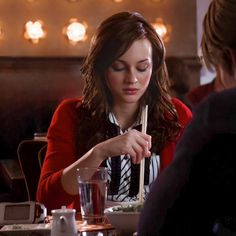 a woman sitting at a table with food in front of her