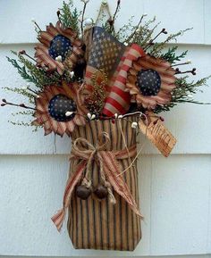 an american flag decoration hanging on the side of a building with flowers and decorations in it