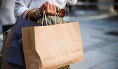 a woman is carrying shopping bags and talking on the phone