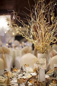 the centerpieces are decorated with branches and gold ribbon, while other tables have silverware on them