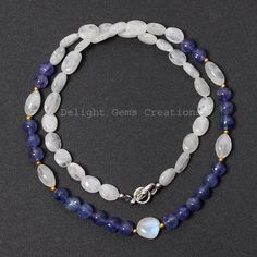 Product Details : ITEM : TANZANITE AND RAINBOW MOONSTONE BEADED NECKLACE Item Code : DGC2580 Gemstone Name : SMOOTH ROUND/ TUMBLE Chain Style : BEADED Beads Shape : SMOOTH ROUND/ SMOOTH OVAL TUMBLE Beads Size : 6.5/8.5x7-11x6.5 mm Approx Length : 18.5 INCH WITH LOBSTER CLASP Weight : 130 Cts. Approx Customization : **Available** Please Feel Free To Contact If You Have Any Query. Natural Oval Beads Gemstones For Jewelry Making, Natural Stone Oval Beads For Jewelry Making, Handmade Oval Beads Gemstones For Gift, Handmade Oval Bead Gemstones For Gift, Oval Natural Stones For Beads, Gems, And Cabochons, Oval Natural Stones For Gifts, White Oval Gemstone Beads Necklaces, Oval Gemstone Beads Necklace Perfect For Gifts, Handmade Oval Bead Gemstones For Jewelry Making