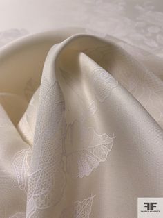 Solid by the panel, this Italian-made floral printed heavy silk gazar comes in a light ivory and white color combination. The heavy silk gazar fabric offers a luxurious and opulent look, while the floral print adds a romantic and feminine touch. It's perfect for creating exquisite and high-end garments like evening gowns, bridal wear, and special occasion dresses. SKU: 16589 Content: 100% Silk Color: Light Ivory / White Width: 56 inches Panel Length: 36 inches Silk Gazar, Golden Fabric, Light Ivory, Ivory White, Fashion Fabric, Cool Fabric, White Fabrics, Color Combination, Floral Printed