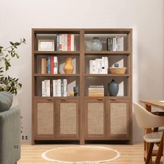 a living room filled with furniture and bookshelves in front of a white wall