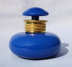 a blue bottle with a gold top on a white background, it is very unusual