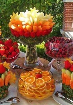 a table topped with lots of different types of fruits and veggie platters