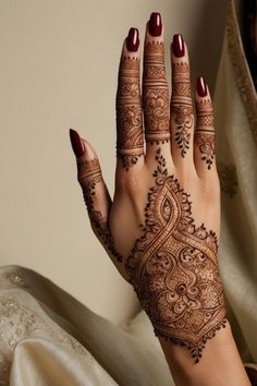 a woman's hand with henna tattoos on it