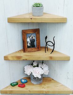 three wooden shelves with pictures and flowers on them