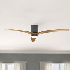 a ceiling fan in a living room with two windows