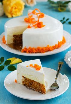 two pieces of carrot cake on plates with flowers in the background and one slice missing