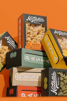 several boxes of pasta are stacked on top of each other in front of an orange background