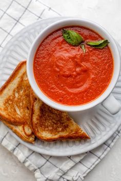 a bowl of tomato soup with grilled bread on the side